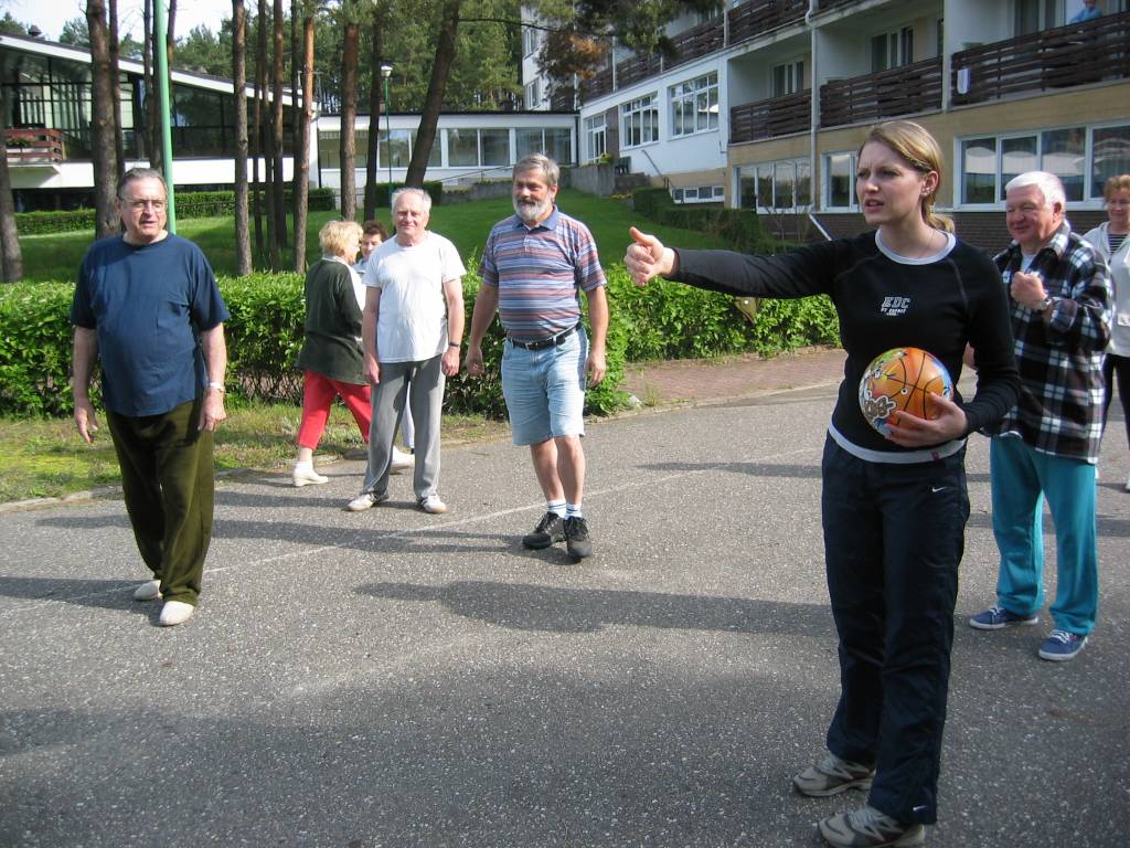 Uczestnicy Turnusu Osiek 2006 r. przed budynkiem sanatorium. Młoda trenerka trzyma piłkę i próbuje zmobilizować uczestników do dalszych ćwiczeń.