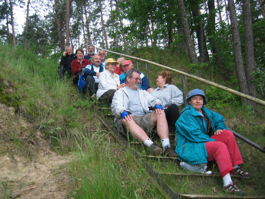 Uczestnicy Turnusu Rehabilitacyjnego Serpelice 2007 r. Pamiątkowe zdjęcie na schodkach w lesie, na których wycieczkowicze siedzą parami.